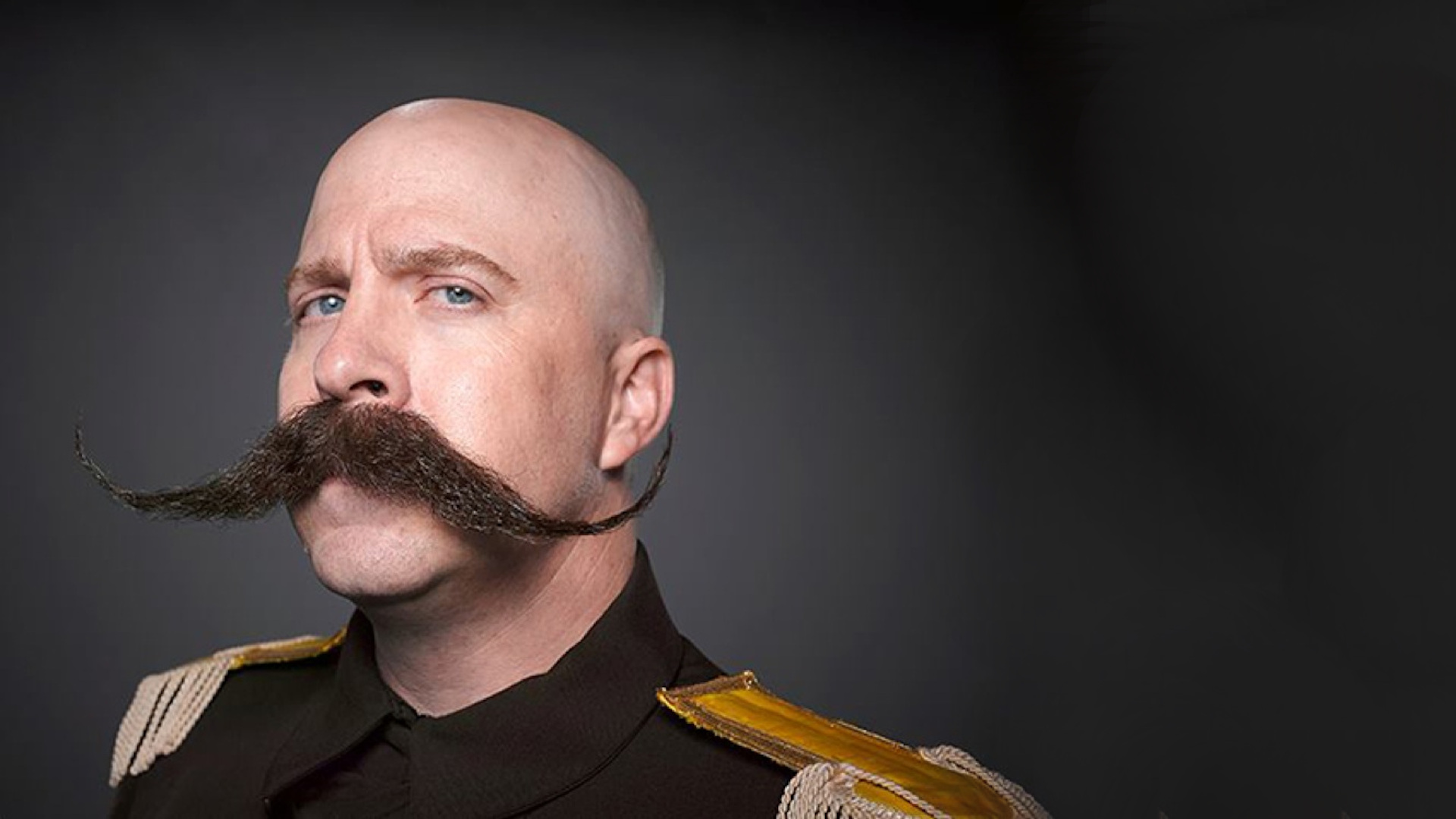 Bald man with handlebar mustache in military uniform